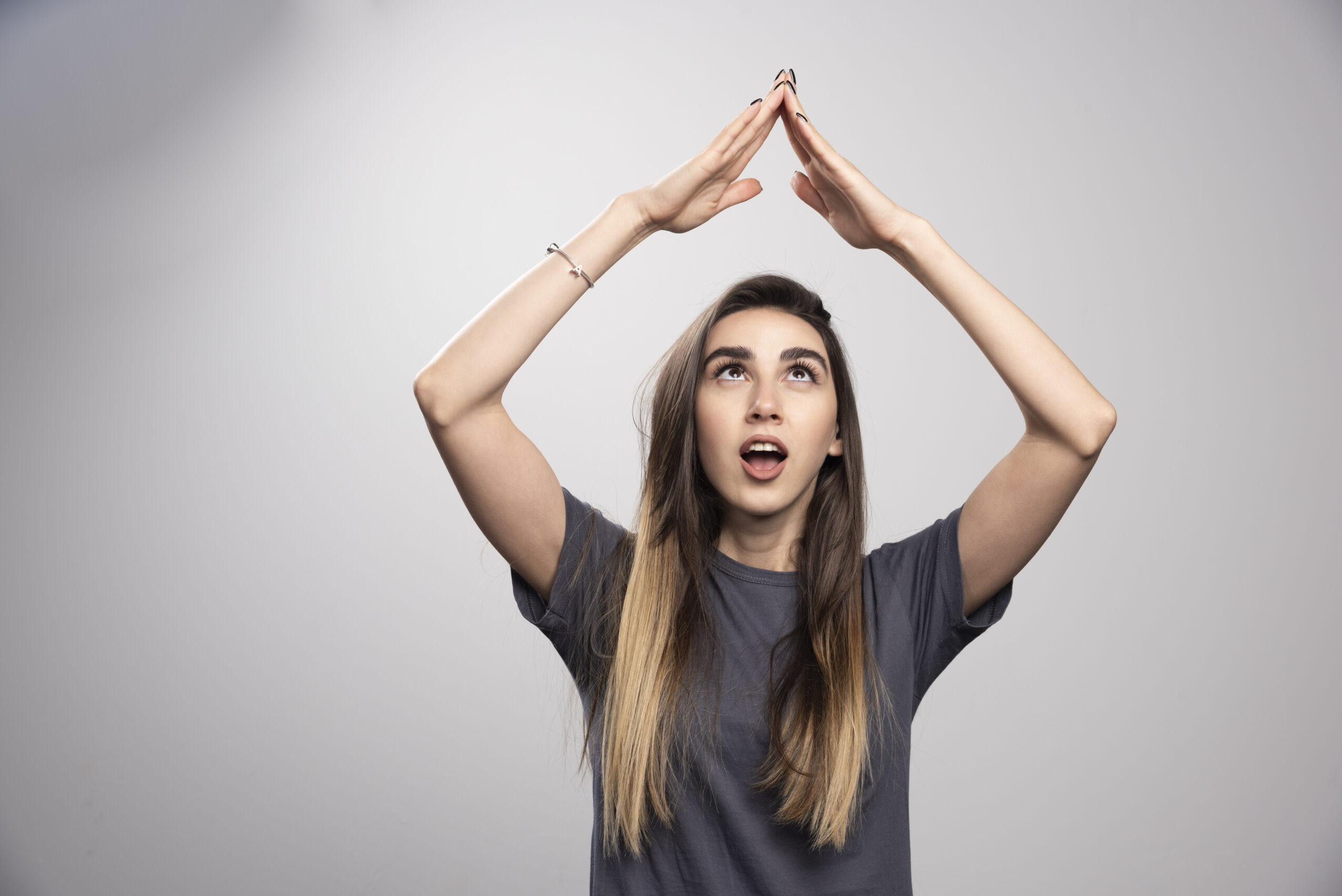young woman standing posing gray background