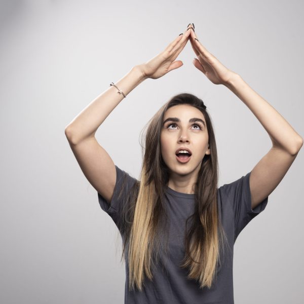 young woman standing posing gray background